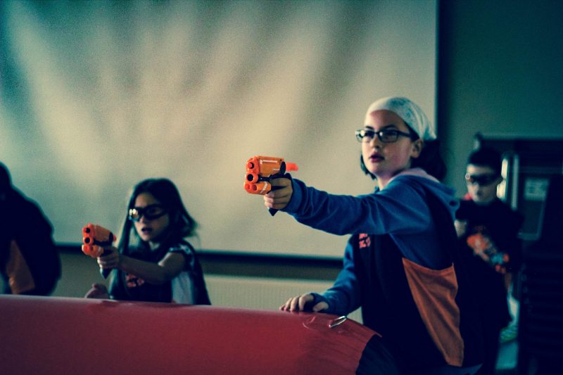 Girl taking aim at a nerf birthday party